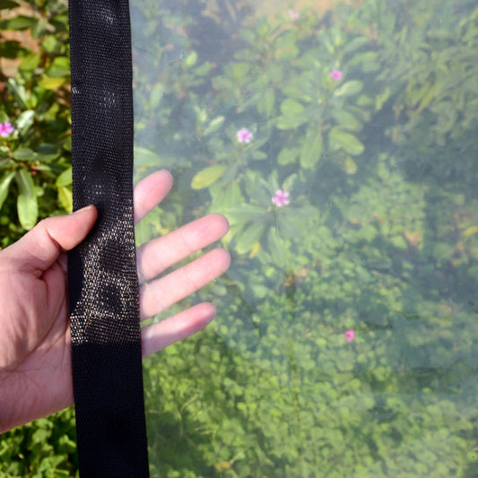 Close-up of black stitched edge strip for clear rainproof film, held in hand