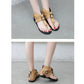 Light brown flat sandals on feet, featuring metal buckle straps and open toe design