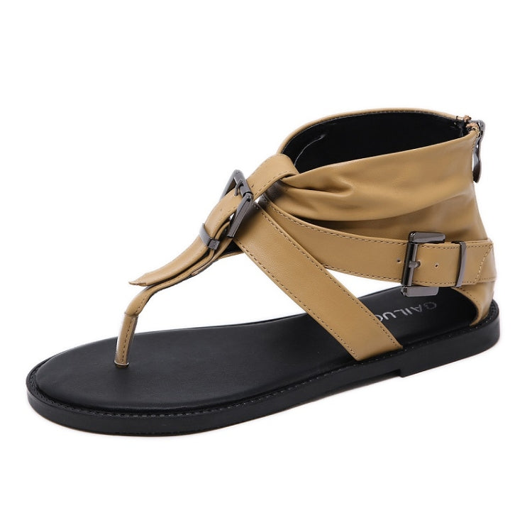 Light brown flip-flop sandals with X straps, metal buckle, and black rubber sole