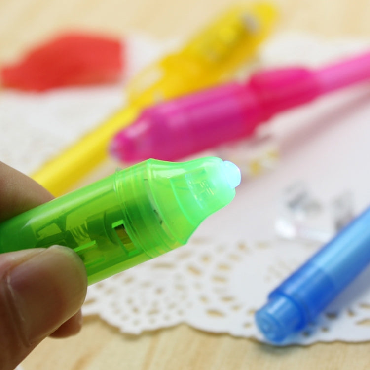Hand holding a green UV invisible ink pen; other translucent pens in view.
