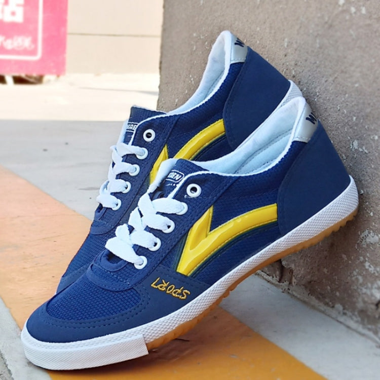 Blue canvas training sneakers with yellow stripe, white laces, gum outsole, front side view