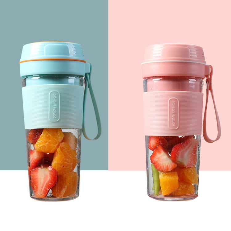 Portable mini juicer cups in blue and pink, both filled with fruit pieces