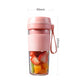 Pink mini juicer cup with fruit pieces inside and side handle, standalone view