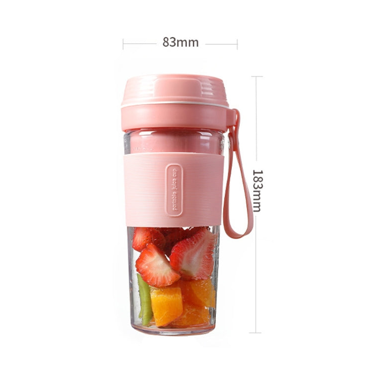 Pink mini juicer cup with fruit pieces inside and side handle, standalone view