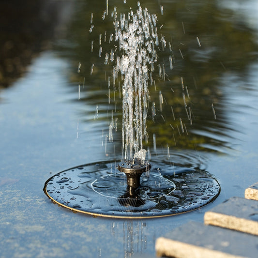 Floating solar water fountain disk with central nozzle spraying into pool