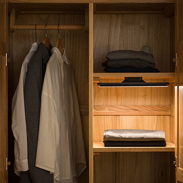 LED desk lamp bar inside wooden wardrobe cabinet providing warm light