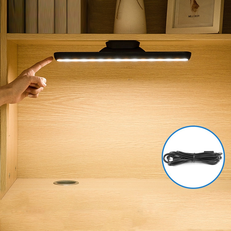 Black LED desk lamp with bright light bar; hand holding lamp and cable inset