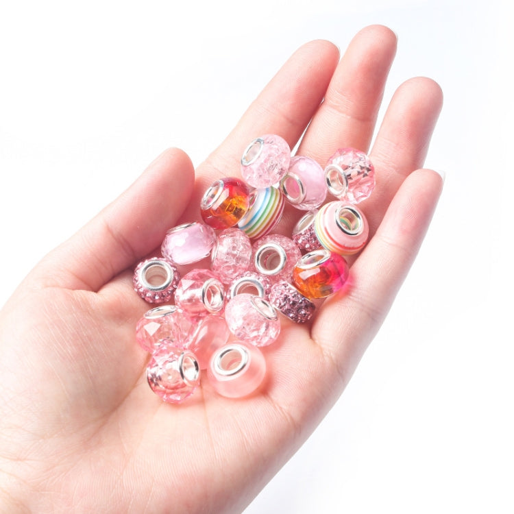 Hand holding pink DIY jewelry beads, faceted and glitter beads in assorted shapes