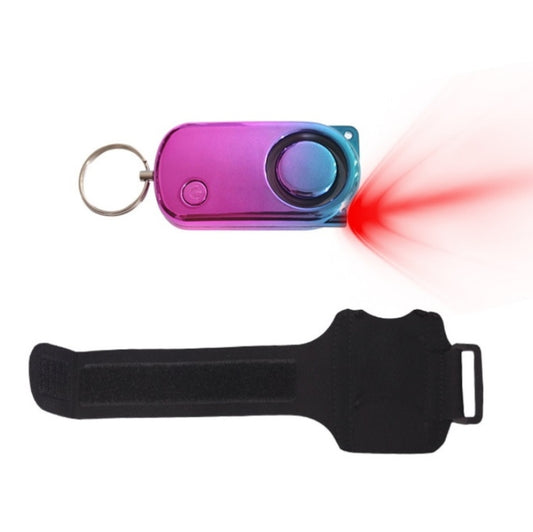 Purple personal safety alarm with wrist strap and keychain ring, blue-lit round button.