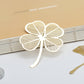 Metal hollow bookmark shaped like a white four-leaf clover with cutout lines