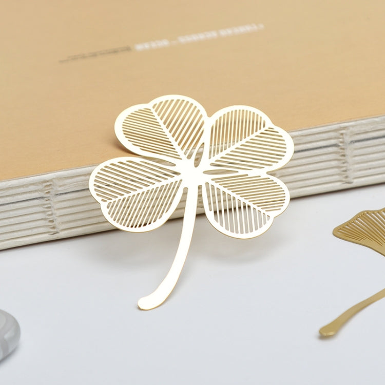 Metal hollow bookmark shaped like a white four-leaf clover with cutout lines