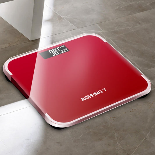 Red battery precision digital bathroom scale with LCD display and rounded platform.