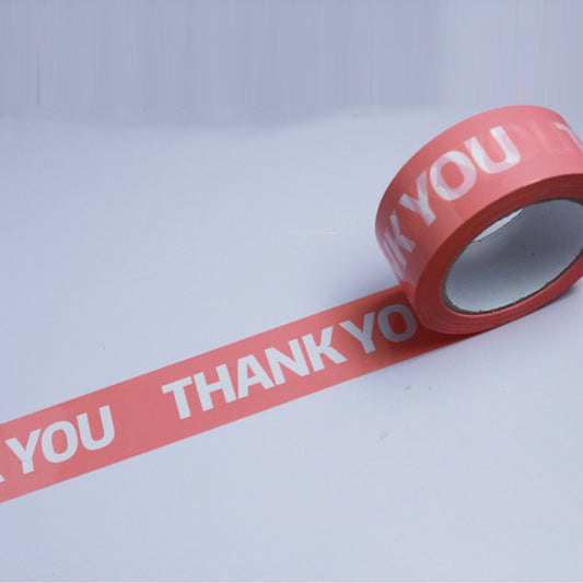 Pink packing sealing tape with white “THANK YOU” text, on a roll.