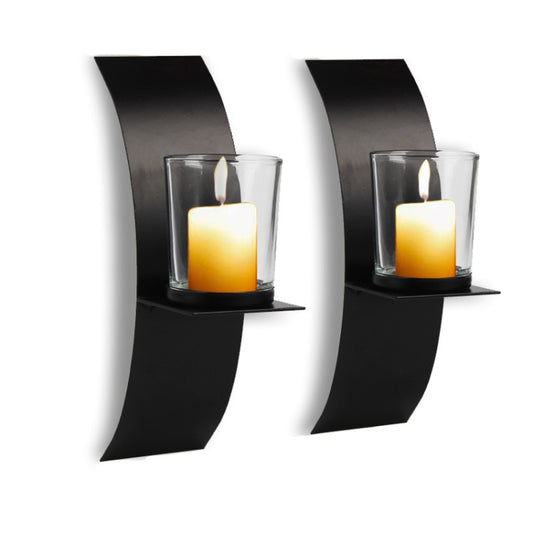 Black arc wall hanging iron candle holder with clear glass cup, holding a lit candle