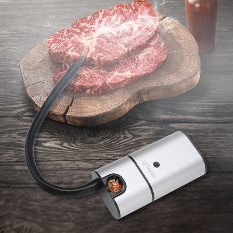 Handheld smoking tool with hose delivering smoke to a steak on a cutting board