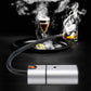 Handheld smoking tool smoking a pan with visible vapor and flame