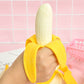 Peeling banana vent toy held on hand: cream banana inside yellow peel