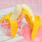 Peeling banana toy on a pink track with yellow peel loops and cream banana halves