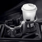 Car dual cup holder holding a white insulated bottle and cup