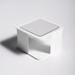 White wall-mounted sponge rack with open front and slotted draining tray