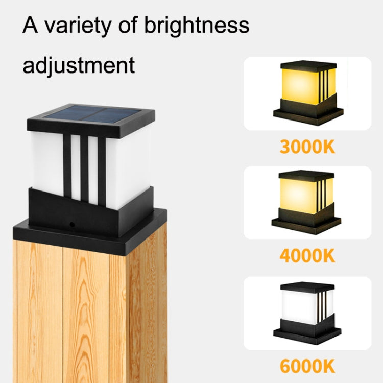 Solar column lamp with black housing and frosted sides, showing warm yellow glow
