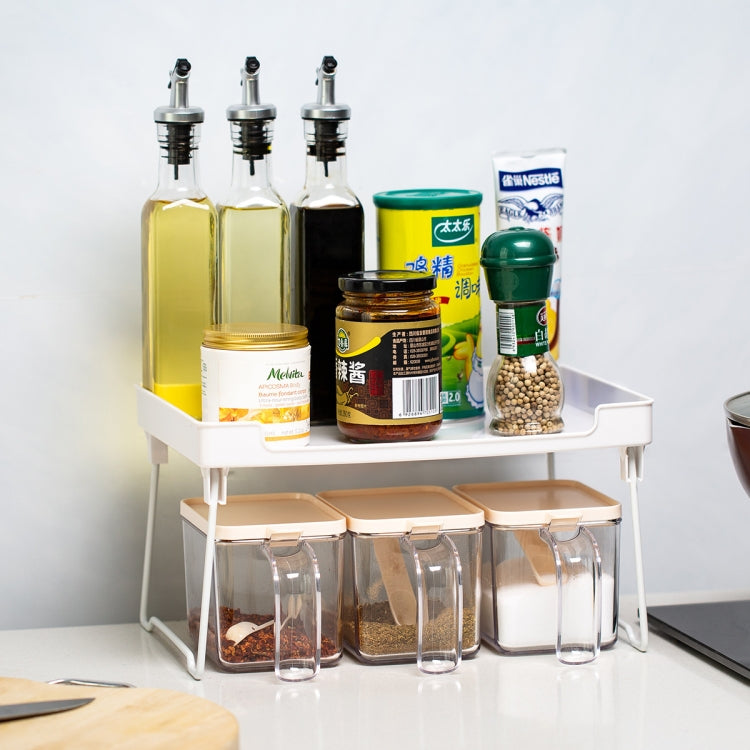 White desktop storage rack with clear compartments holding bottles, jars, and canisters
