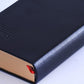 A5 diary notebook corner close-up with red ribbon bookmark and black cover
