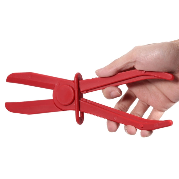 Red nylon hose clamp plier held by hand, showing clamp arms and latch