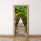 Wood-framed door decoration sticker with a boardwalk path through dense green trees.