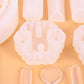 Silicone mold tray close-up showing round floral pendant cavity and heart cavity