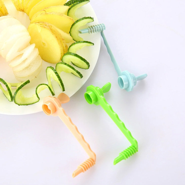 Multi-color carrot spiral slicers with spiral-cut vegetable pieces on plate