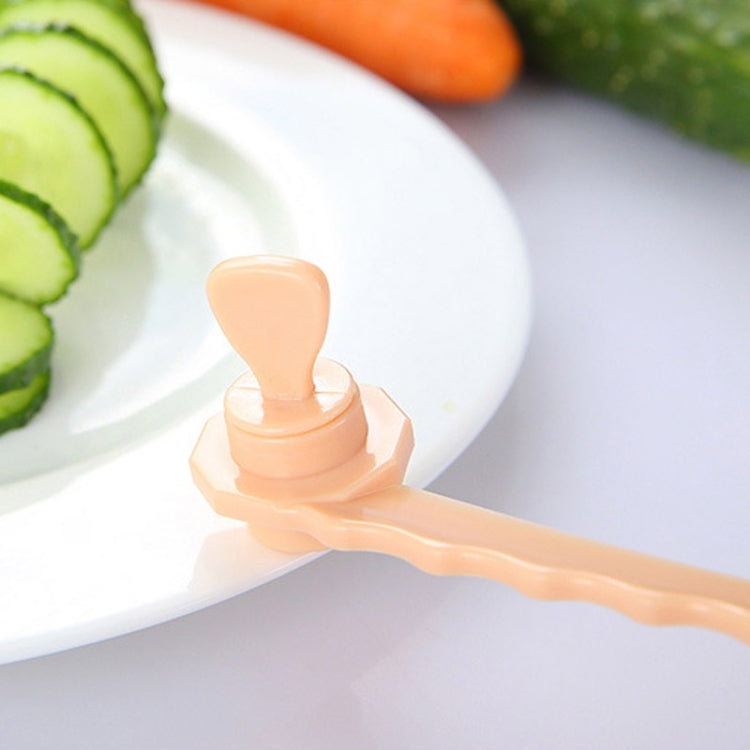 Beige carrot spiral slicer handle with spiral cutter bit on serving plate