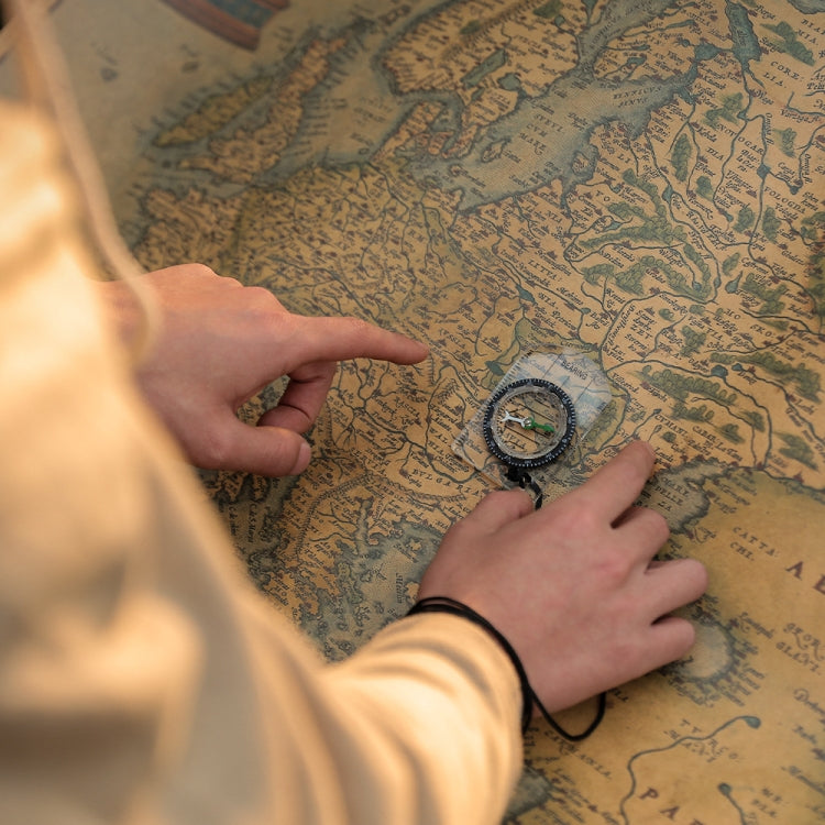 2-in-1 compass on a map with hands; clear body and black braided lanyard