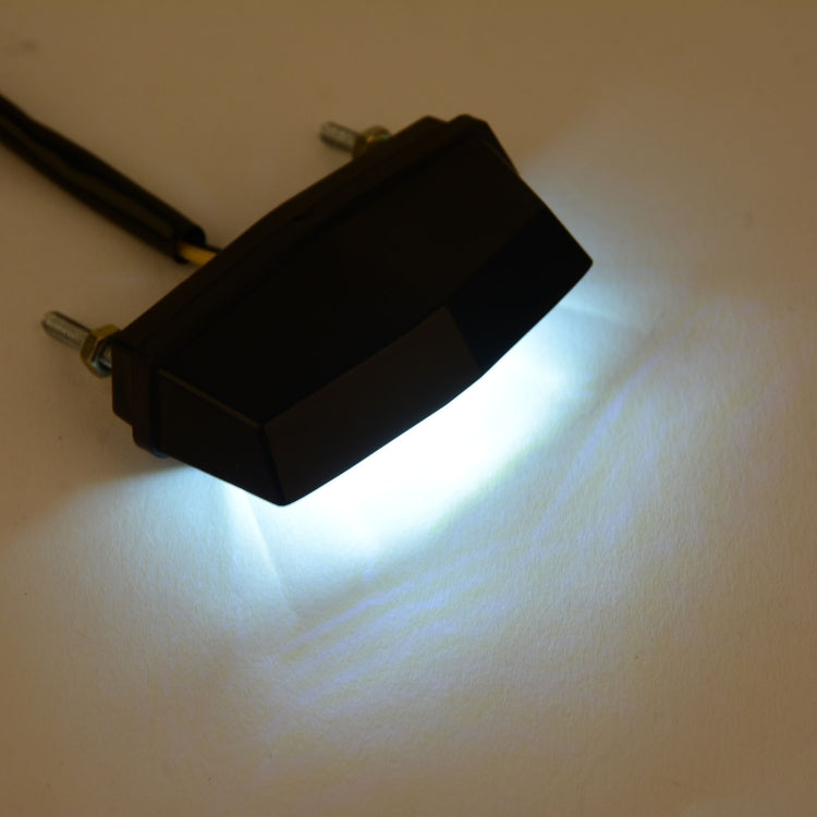 Motorcycle LED license plate taillight light glowing with bright white beam