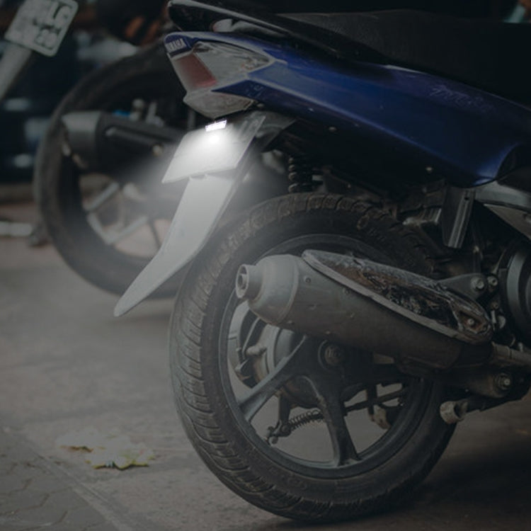 Motorcycle LED license plate taillight mounted on bike, emitting bright white light