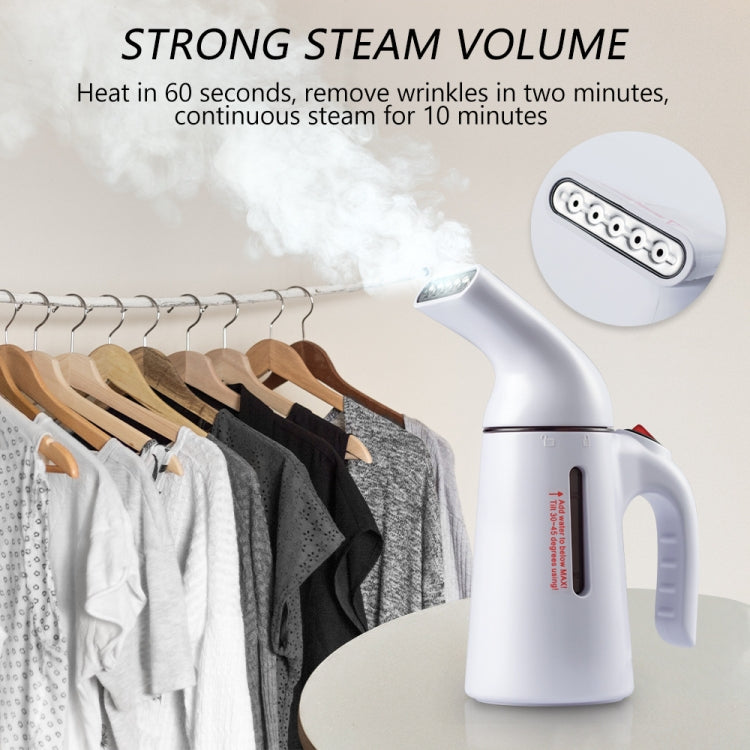 Handheld garment steamer with nozzle, releasing steam toward hanging clothes