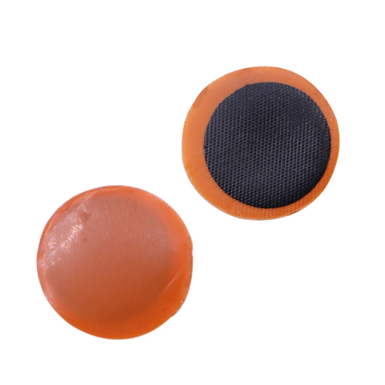 Two round tire repair patches with dark centers and orange edges