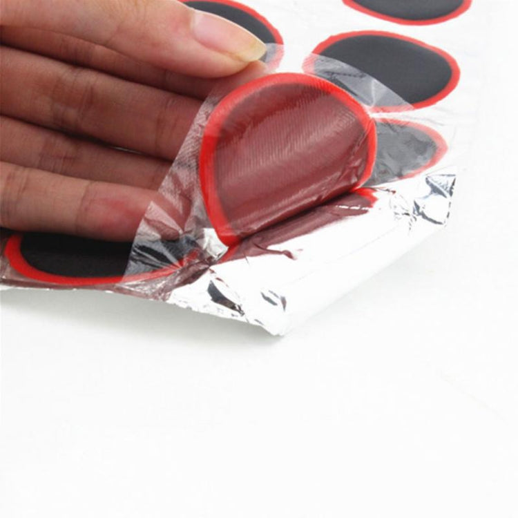 Hand holding a sheet of tire repair patches on clear backing