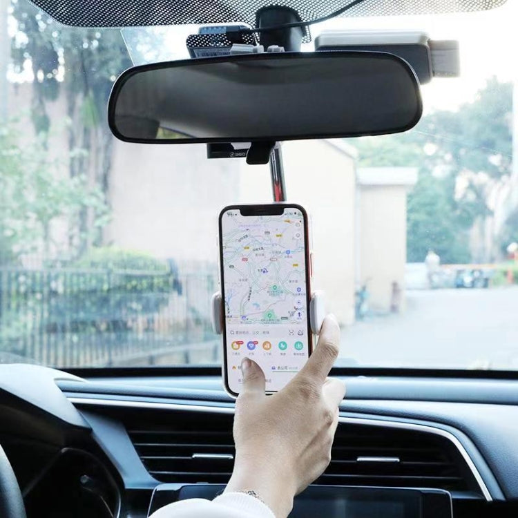 Car rearview mirror phone mount holding a smartphone with navigation screen