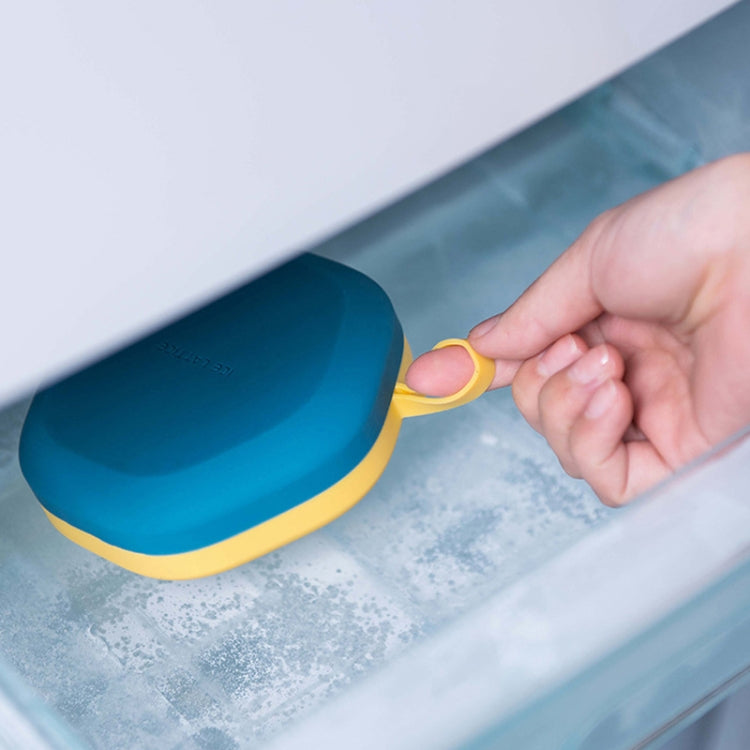 Blue hexagonal ice cube tray with yellow rim sliding into freezer bin
