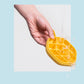 Yellow hexagonal ice cube tray pouring ice cubes, with hand holding lid