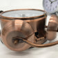 Copper-tone alarm clock underside detail with double bells and side adjustment hardware