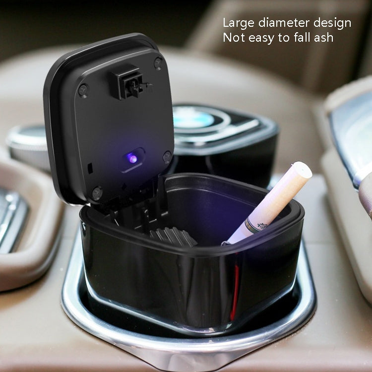 Opened black car ashtray with cigarette holder slot and glowing indicator light