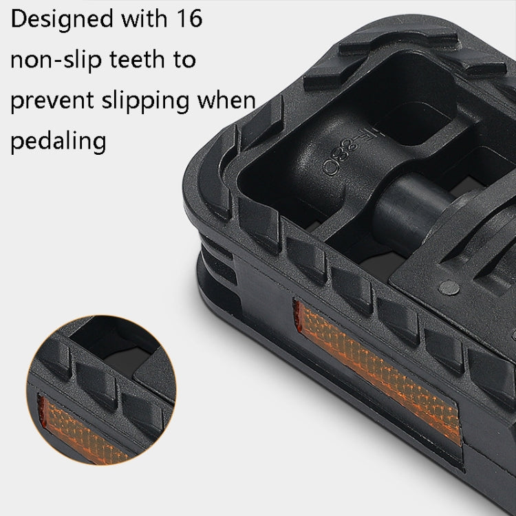 Black folding bicycle pedal with non-slip teeth and orange side reflector, close-up