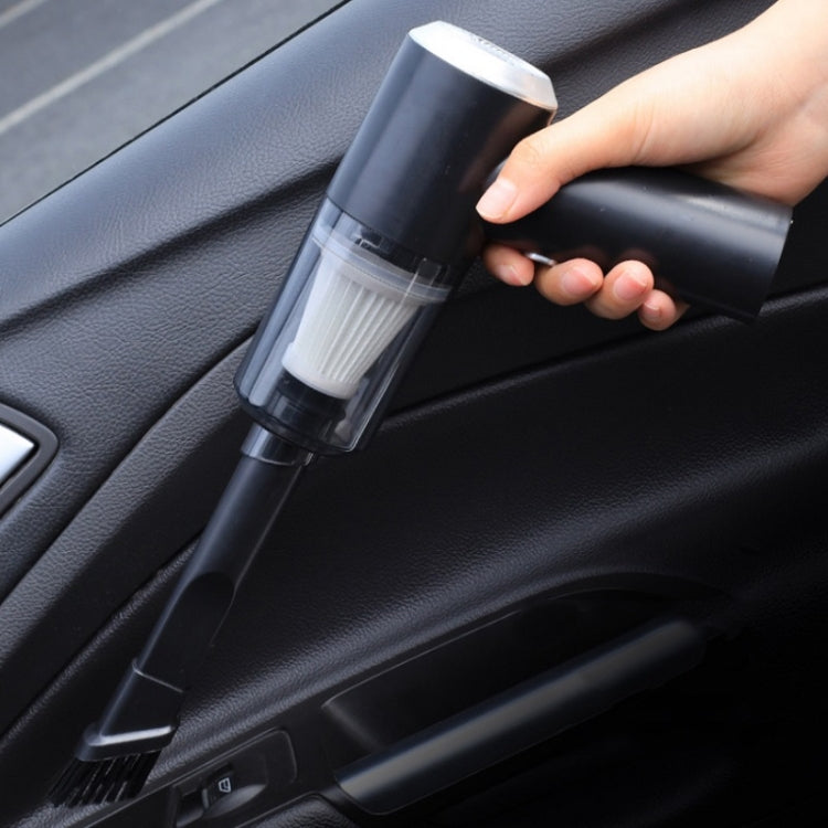 Black handheld vacuum cleaner cleaning car seat seam with bristle nozzle