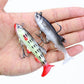 Two fishing lures in hand, one gray and one green with red tails and hooks.