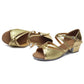 Gold glitter low-heel dance shoes with crisscross straps and soft sole.