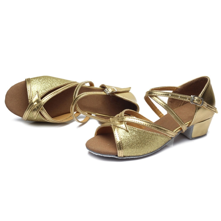 Gold glitter low-heel dance shoes with crisscross straps and soft sole.