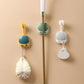 Bathroom shower bracket set with yellow, mint, and white holders and hanging loofahs