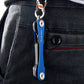 Blue metal emergency tool keychain clipped to a jeans pocket with key tools extended